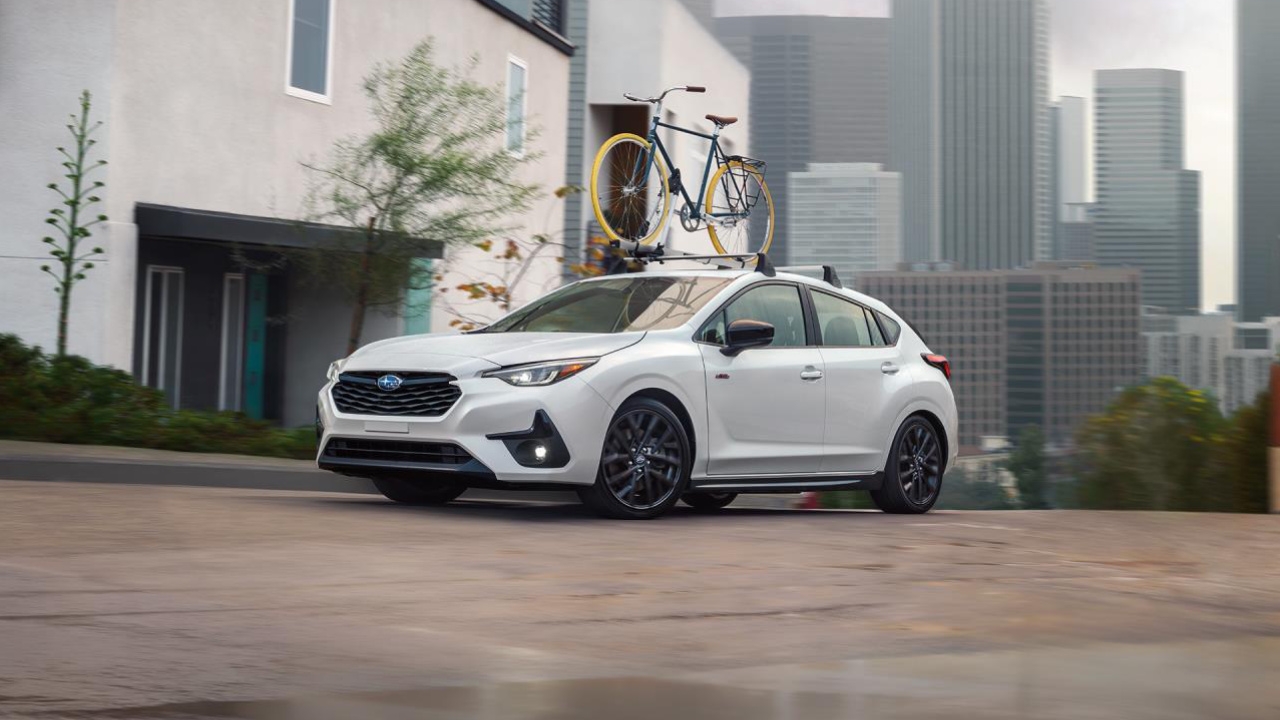 vue latérale avant d'un Subaru Impreza 2025 devant une maison avec un vélo sur son toit